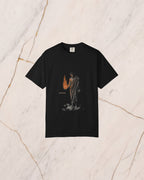 The PROMETHEUS shirt in black, laid on pale marble. Prometheus holds the stolen fire in his open hand, and its light falls on his forearm, his chest and the underside of his beard.