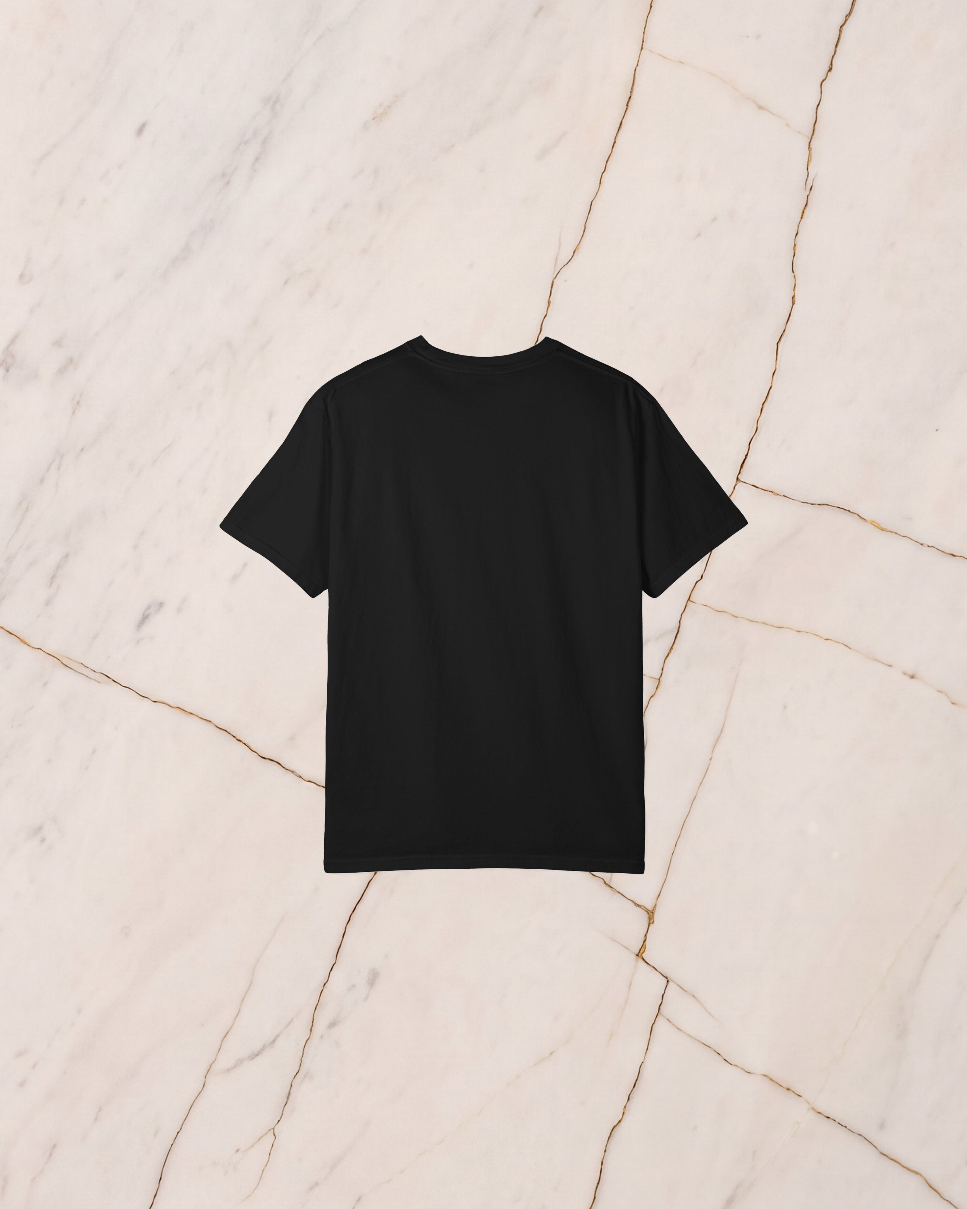 The back of the PROMETHEUS shirt, plain black, laid on pale marble.