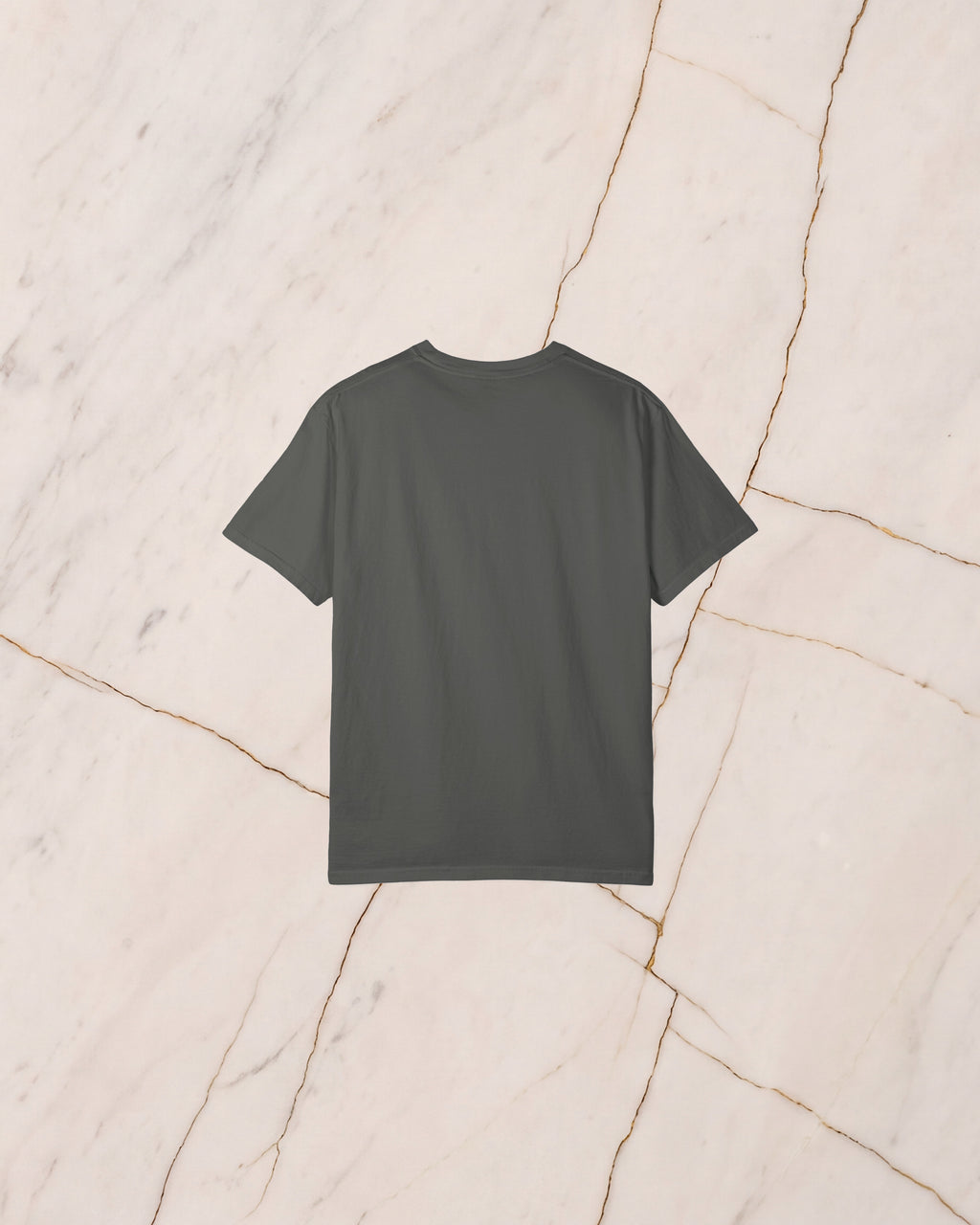 The back of the SISYPHUS shirt, plain pepper, laid on pale marble.